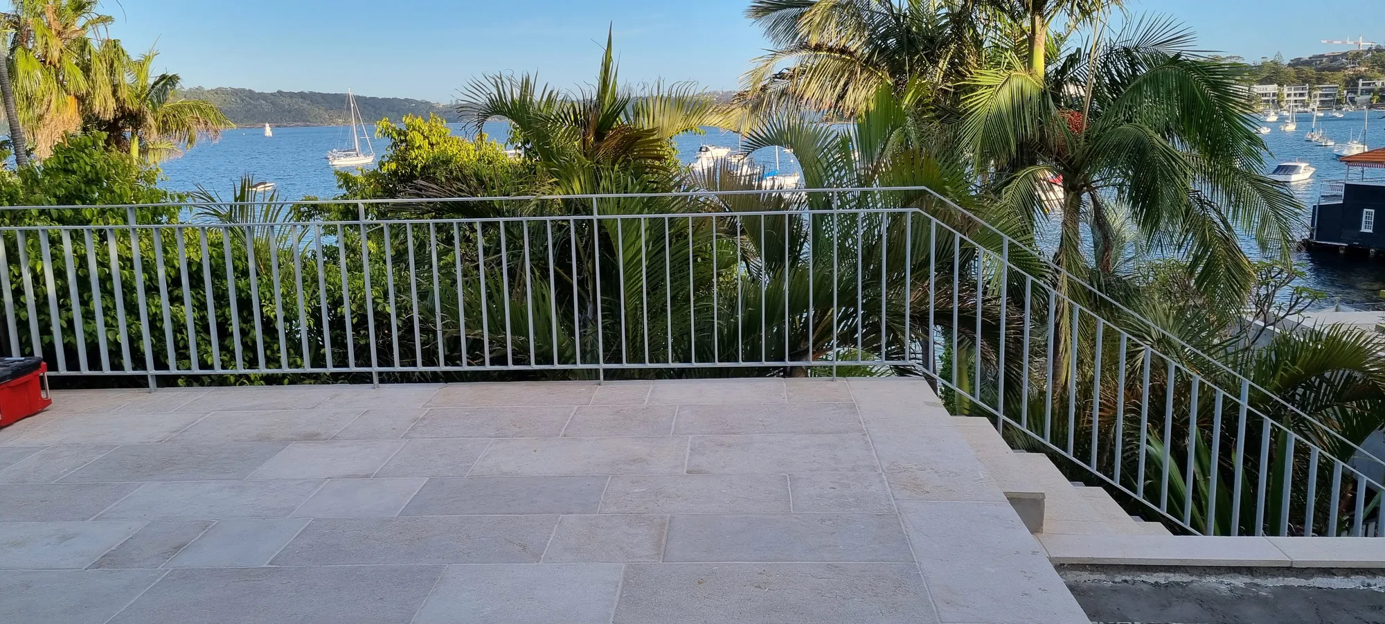 Metal balustrade on a waterfront terrace overlooking a boat-filled bay.