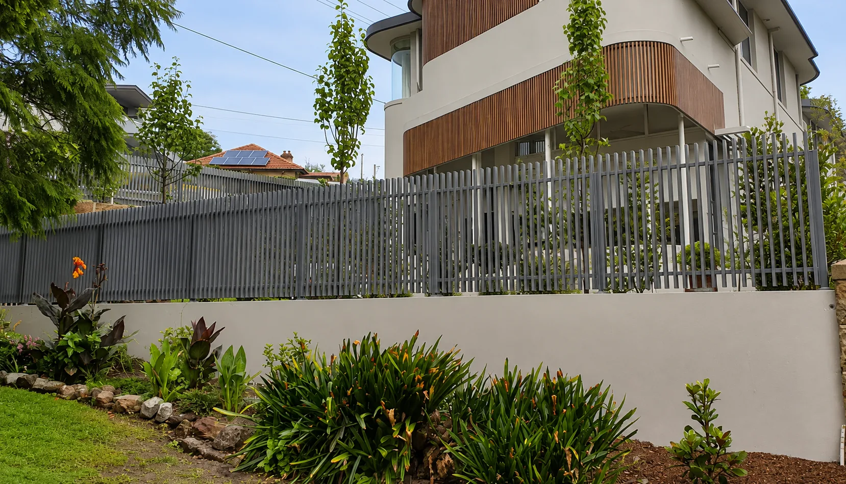 Aluminium vertical-picket fence on a rendered wall.