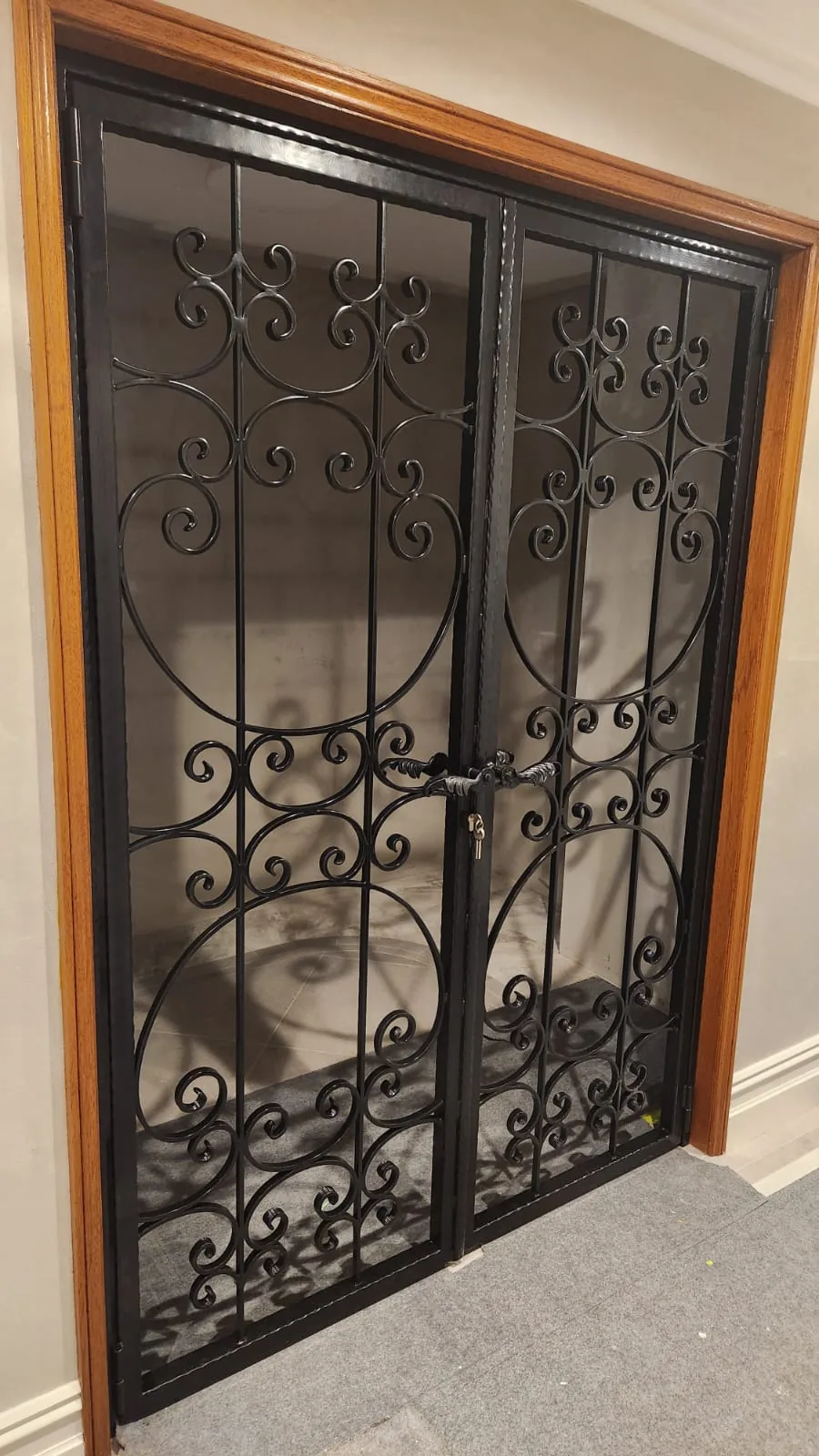 Ornate wrought-iron double gate with traditional scrollwork.