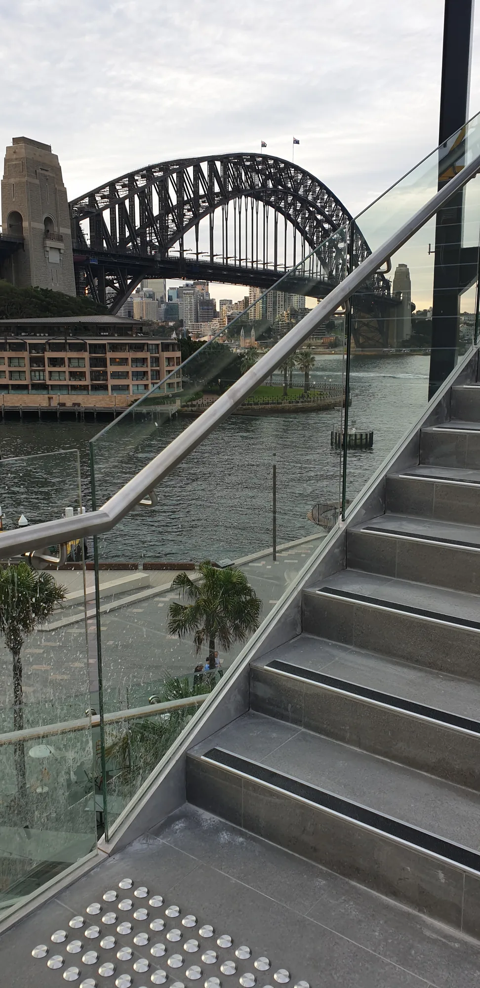 Custom fabricated black steel spiral staircase with glass balustrade on a coastal property.