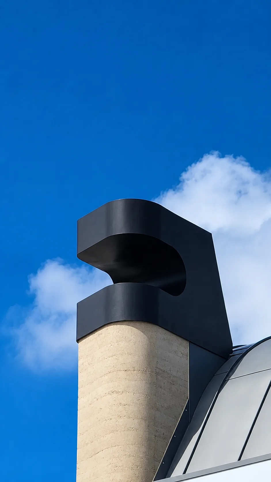 Curved steel awning and hood feature on a rooftop.