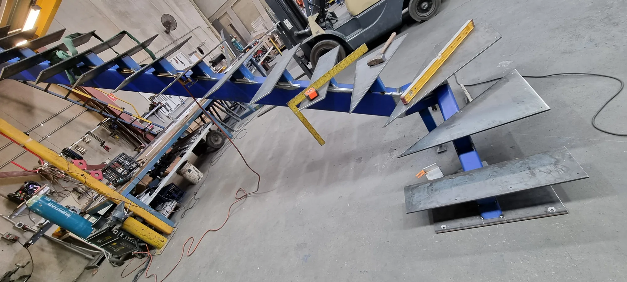 Zig-zag cut steel stair stringers fabricated on the workshop floor.